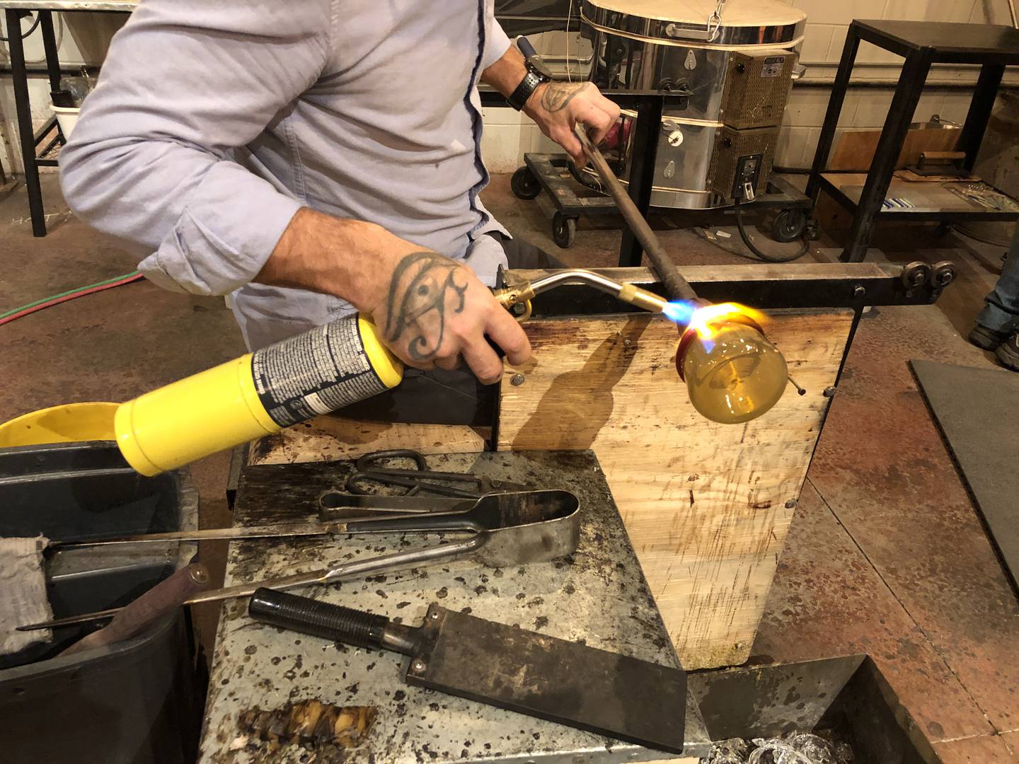 Brian Dunlavy at The Glass Smith in downtown Richmond uses a torch to add the strip to a leprechaun hat on Thursday, March 14, 2024.