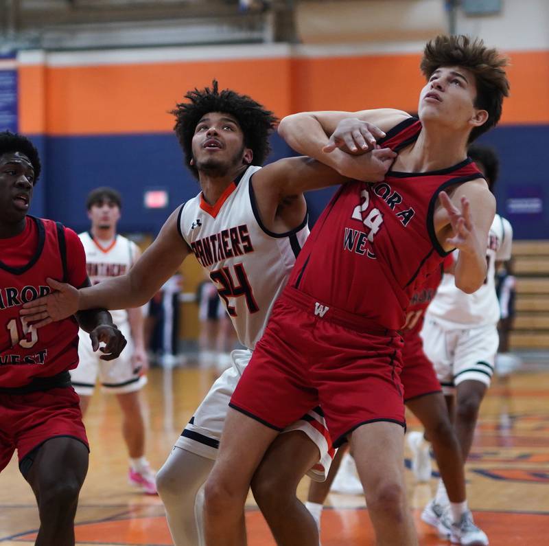 Oswego’s Taiden Thomas (left) and Gabriel Gonzales fight for position under the basket during a basketball game at Oswego High School on Friday, Dec 1, 2023.