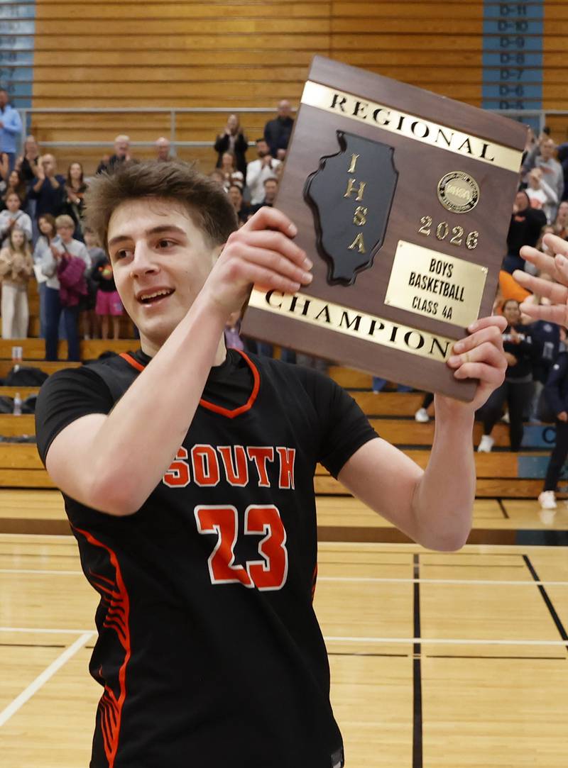 Wheaton Warrenville South's David Showman (23) holds the championship plaque after winning the IHSA boys class 4A Willowbrook regional final between Wheaton Warrenville South and Batavia on Friday, Feb. 27, 2026 in Villa Park, IL.