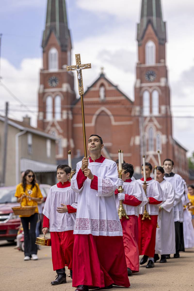 Ulysses Marquez glances up at the cross Sunday, June 2, 2024, as the Corpus Christi procession makes it way down Tonti Street in La Salle.