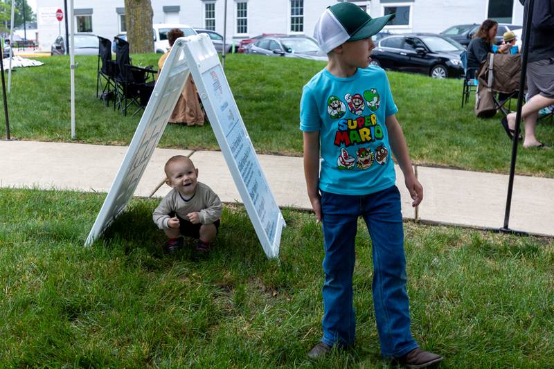 (left to right) Everett Eckberg sits under sign and watches Dallas Eckberg at the annual Shrimp Fest on Saturday, June 7, 2025 at Rotary Park in Princeton.
