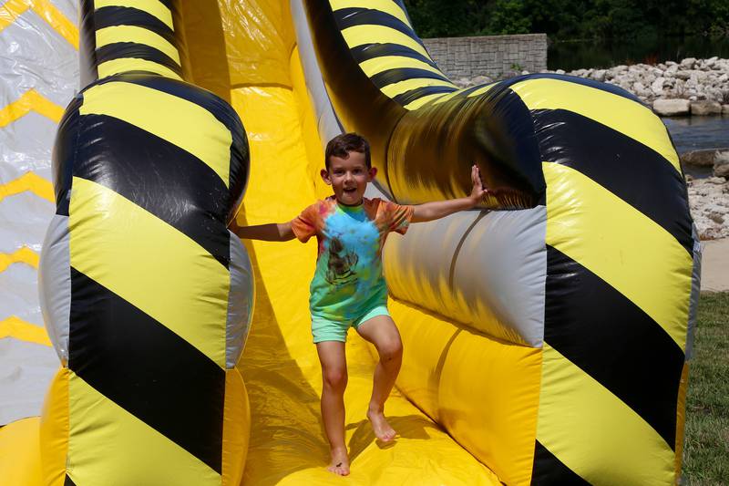 Six-year old Elliott Kozielski runs off one of the inflatable slides at Yorkville River Fest on Saturday, July 19, 2025.