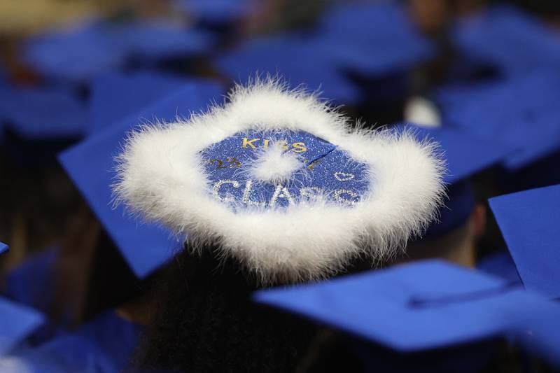 A graduate customizes their hat at the Joliet Central Class of 2023 Commencement Ceremony on Saturday, May 20, 2023, in Joliet.