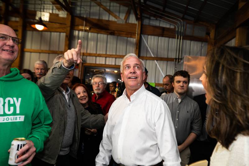 Gregg Kessling points to a TV displaying election results as Terry D'Arcy enters his election night event at Inwood Golf Course, in Joliet, on Tuesday, April 4, 2023.