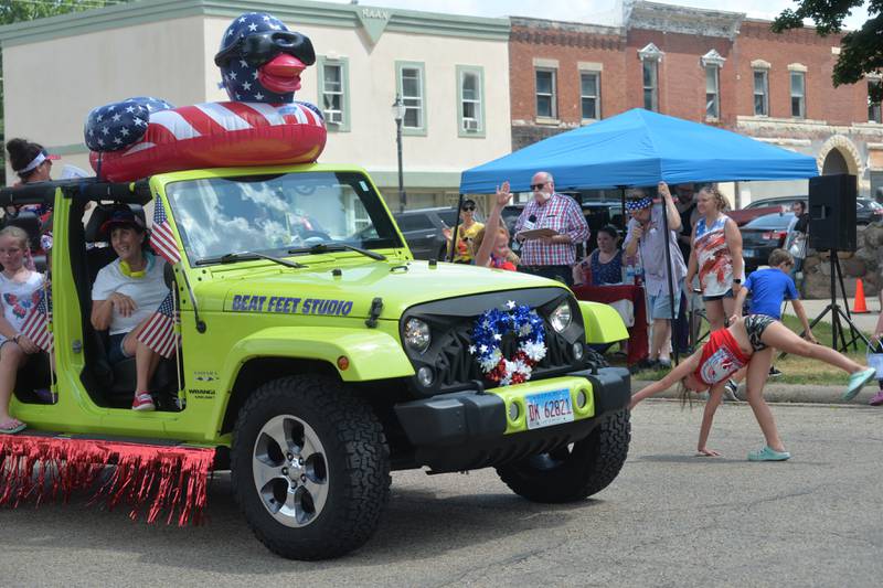 A girl does a cartwheel alongside a decorated Jeep for Beat Feet Studio during the 2023 Let Freedom Ring parade on Tuesday,  July 4.