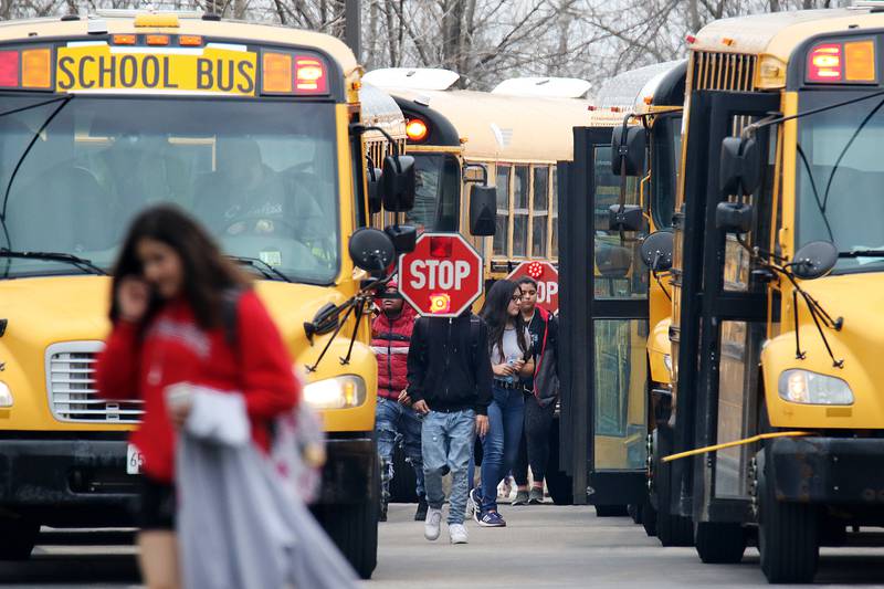 Students board the buses and head home at the end of the school day at Dundee-Crown High School on Wednesday, March 11, 2020 in Carpentersville.  District 300 released an email to parents informing them that a student who attends the school and their family had been told to "self-quarantine by the McHenry County Health Department while they await test results for another member of their immediate family."  The school will be closed Thursday and Friday and hopes to reopen Monday after a comprehensive cleaning.