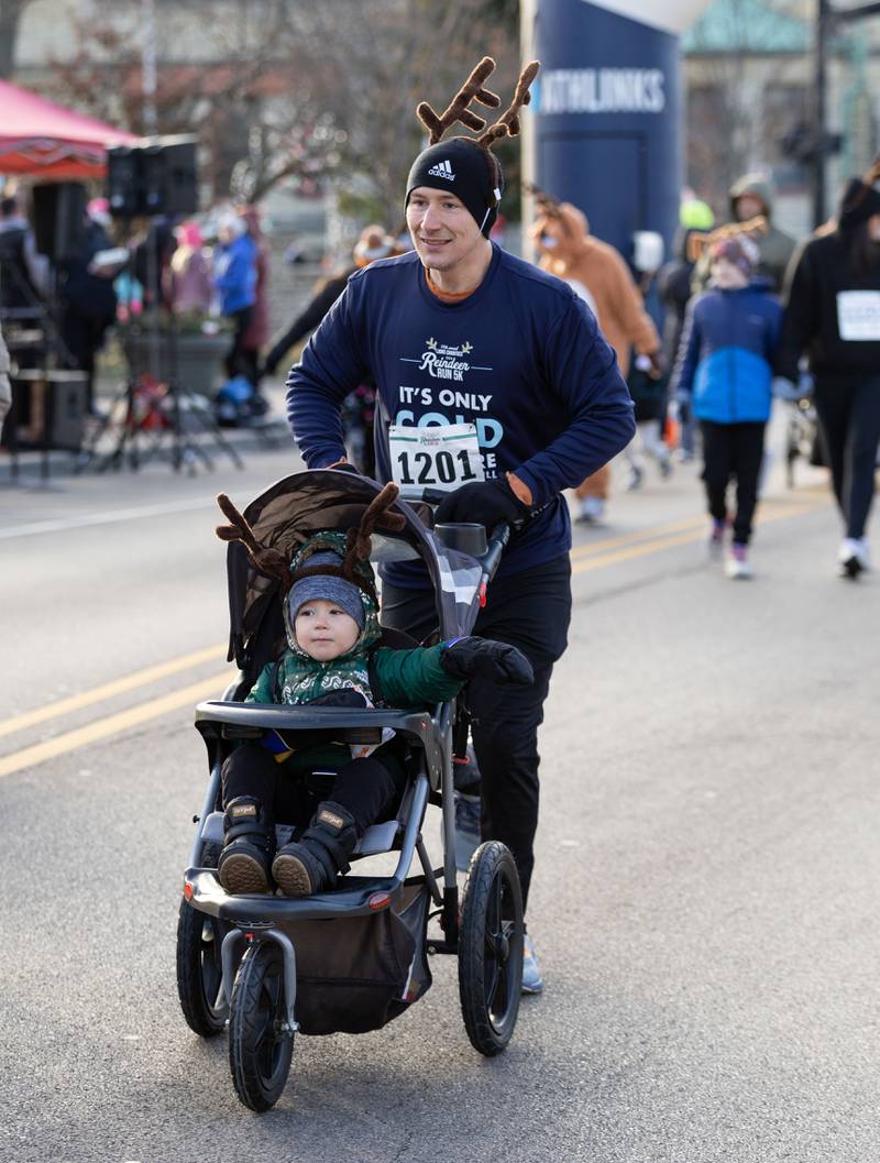 Joey Staiton runs with his son Lukas Staiton in a stroller during the 13th annual Lions Charities Reindeer Run 5K Wheaton on Saturday, Dec. 7, 2024.