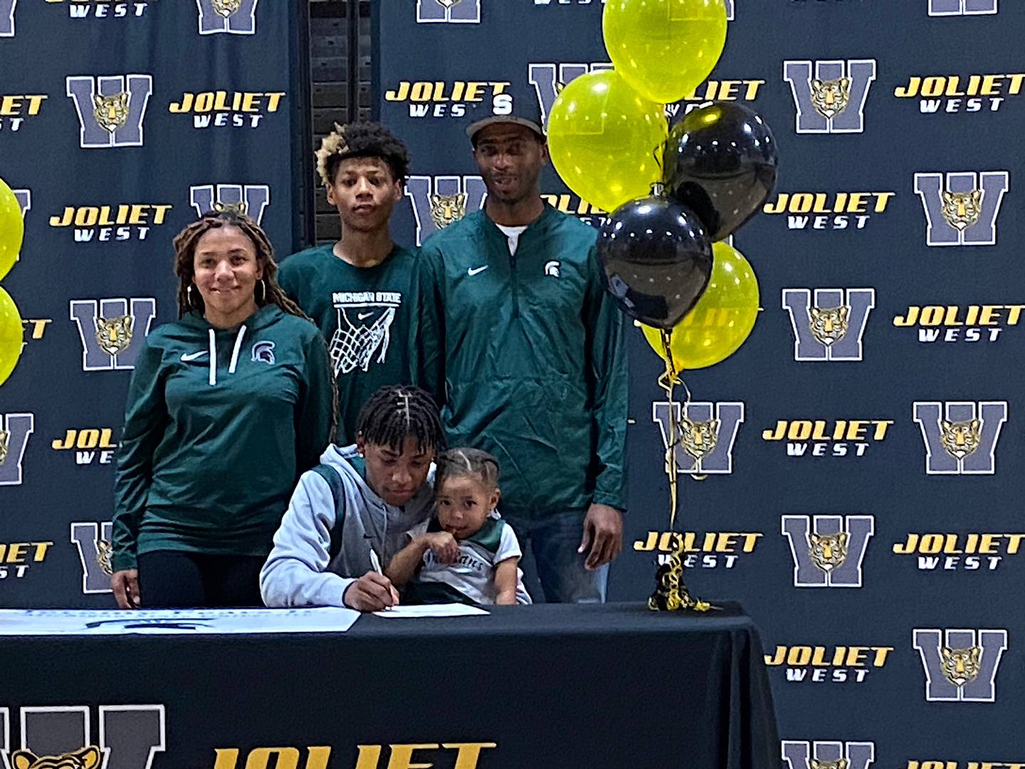 Joliet West's Jeremy Fears, Jr. signs his national letter-of-intent to play basketball for Michigan State University with his sister Skylar on his lap. In the back row, from left, are mother Sekia, brother Jeremiah and father Jeremy, Sr.