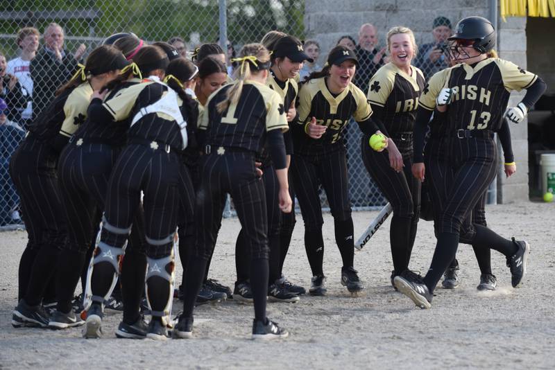 Bishop McNamara's Emma Thyfault (13) is greeted by her Fightin' Irish teammates at home plate after hitting a home run during a home game against Bradley-Bourbonnais Thursday, May 7, 2026.