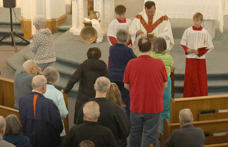 Fr. Jeff Windy, delivers Holy Communion to parishionersduring Holy Thursday Mass on Thursday, March 2, 2026 at St. Mary's Catholic Church in Utica.