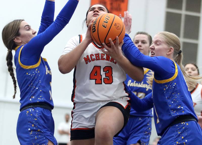 McHenry’s  Maritza Martinez splits Johnsburg’s defense of Ava Jablonski, left, and Carlie Majercik, right, in varsity girls basketball on Saturday, Jan. 4, 2025, at McHenry High School in McHenry.