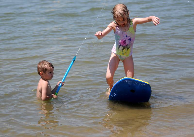 Mikey Broughman. 3, and his sister Adeline, 6, of McHenry, play Tuesday, June 14, 2022, in the cool waters of McCullom Lake at Petersen Park Beach, as temperatures in the McHenry County area reached the mid-90’s.