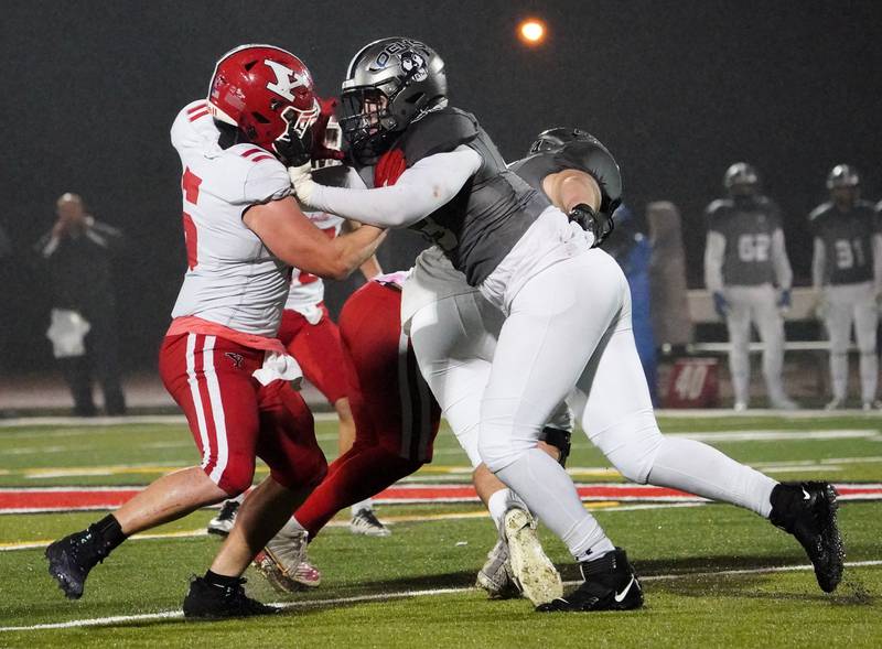 Yorkville's Ben Alvarez (5) and Oswego East's Zachary Clarke (63) battle for position on the line of scrimmage during a football game at Yorkville High School on Friday, Oct. 13, 2023.