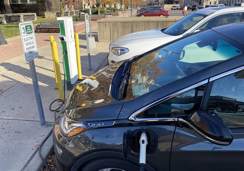 A pair of electric vehicles charge outside of the Illinois State Capitol Complex.