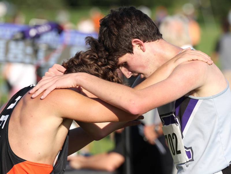 Rochelle’s Declan McGee (right) embraces a Freeport runner after finishing the varsity race Tuesday, Sept. 2, 2025, during the Sycamore Cross Country Invitational at Northern Illinois University in DeKalb.