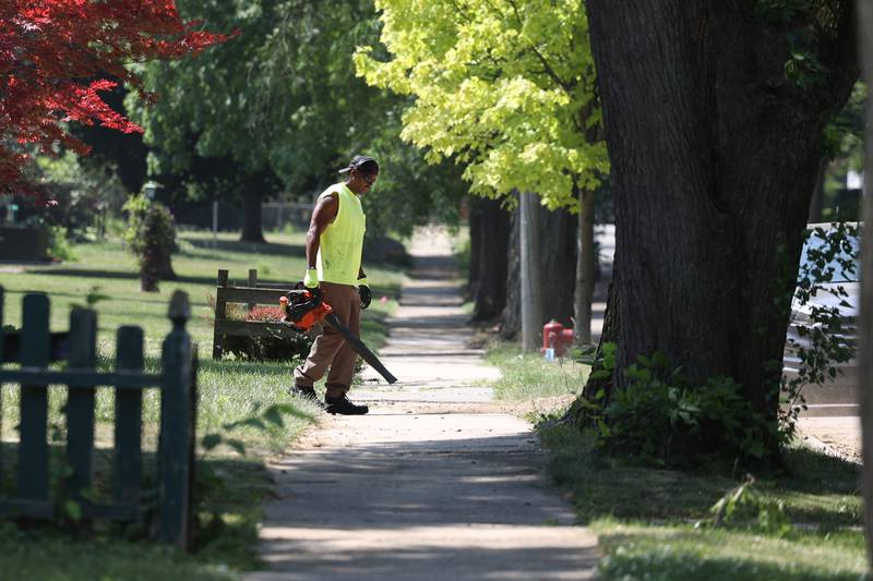 A crew member cleans off the sidewalk after working along Earl Avenue on Tuesday, June 20, 2023 in Joliet.