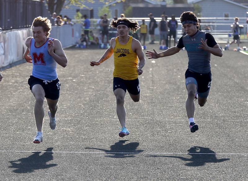 Marian Central ’s Wilson Jakubowicz, (left) Jacobs’s Kieran Nally (center) and 
w\Woodstock North’s Adan Castaneda race to the finish line in the 100 meter dash on Thursday, April 23, 2026, during the McHenry County Track and Field Meet at McCracken Field in McHenry.
