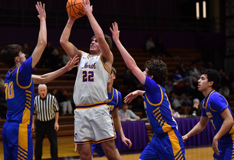 Downers Grove North’s Jacob Vroman (22) goes to the basket in a crowd of Lyons Township defenders during a game on January 15, 2026 at Downers Grove North High School in Downers Grove .