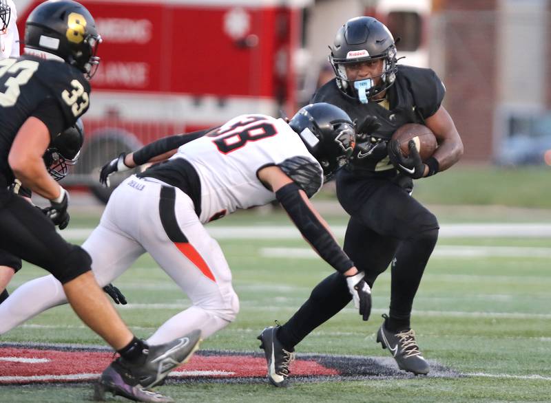 Sycamore's Tyler Curtis tries to get outside of DeKalb’s Otto Eidsness during the First National Challenge game Friday, Aug. 25, 2023, in Huskie Stadium at Northern Illinois University in DeKalb.