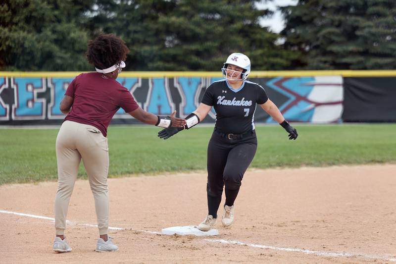 Kankakee's Kylee Cunningham high fives head coach LaDesha Nelson as she rounds third base after hitting a 2-run homer during the Kays' 16-0 victory over Thornridge on Wednesday, May 7, 2025.