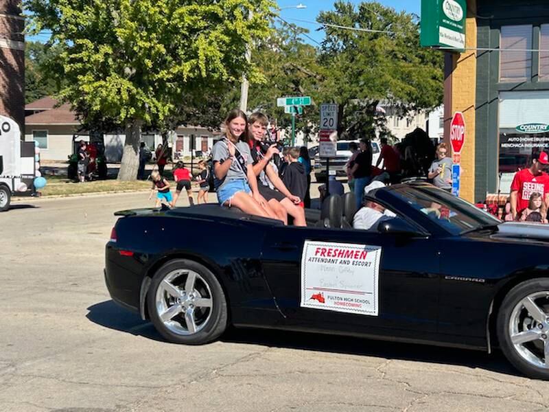 Freshman attendants Wrenn Coffey and Easton Spooner wave to the crowd Friday, Sept. 20, 2024, at Fulton High School's Homecoming parade.