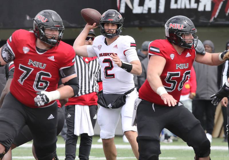 Northern Illinois quarterback Ethan Hampton sets up behind the blocking of offensive linemen John Champe (left) and Pete Nygra during the Spring Showcase Saturday, April 22, 2023, at Huskie Stadium at NIU in DeKalb.