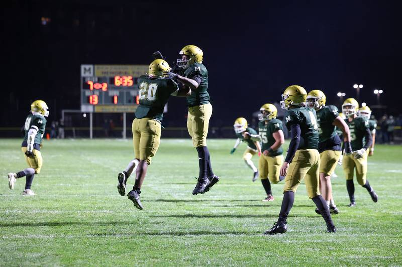 Bishop McNamara's Jordan Callaway, left, leaps in celebration of his touchdown with teammate Julius May during Bishop McNamara's 38-14 victory over Herscher in the IHSA Class 3A first round playoff game on Friday, Oct. 31, 2025.