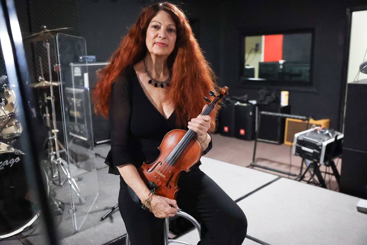 Violinist Scarlet Rivera, best known for her work with Bob Dylan on his 1976 album Desire and Rolling Thunder Revue tour, poses for a photo on a stage at the Illinois Rock and Roll Museum on Tuesday, Aug. 8, 2023 in Joliet.