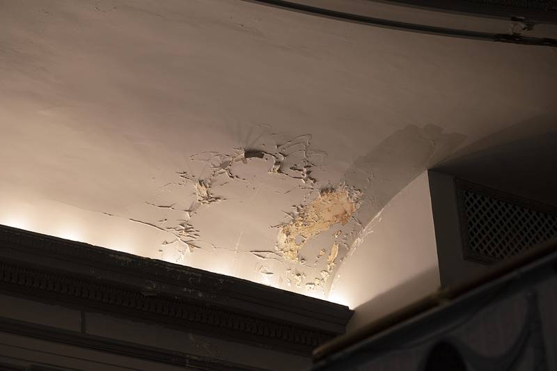The leaky roof has caused plaster to chip and peel in the theater. Roof repair is the most important job needing to be done.