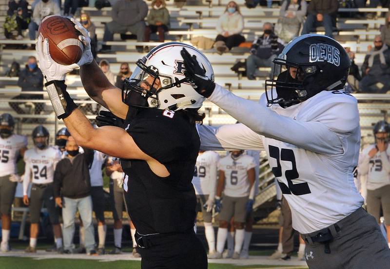 Plainfield North wide receiver Dylan Rasmason (8) makes a catch in front of Oswego East defensive back Austin Miller (22) during a varsity football game at Plainfield North High School on April 16.