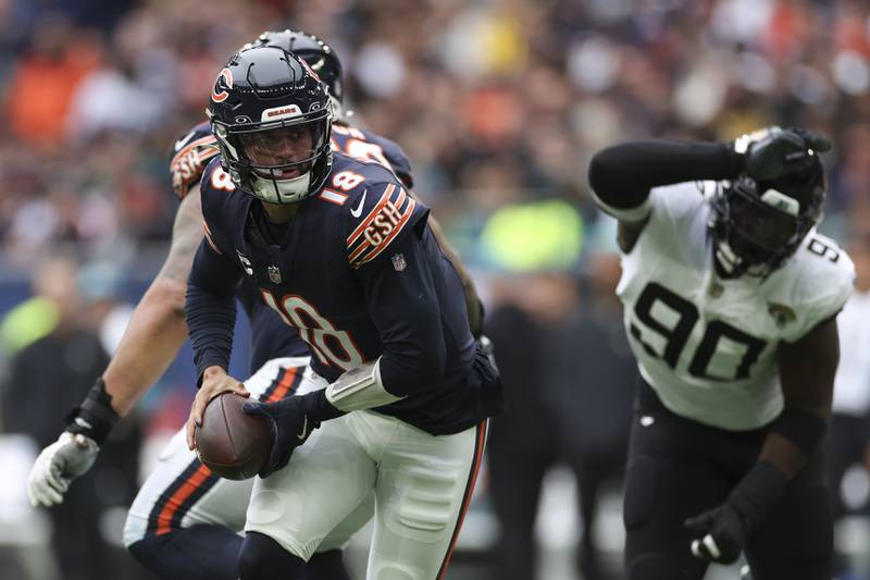 Chicago Bears quarterback Caleb Williams (18) looks to hand off during an NFL football game at the Tottenham Hotspur stadium between the Jacksonville Jaguars and Chicago Bears in London, Sunday, Oct. 13, 2024.