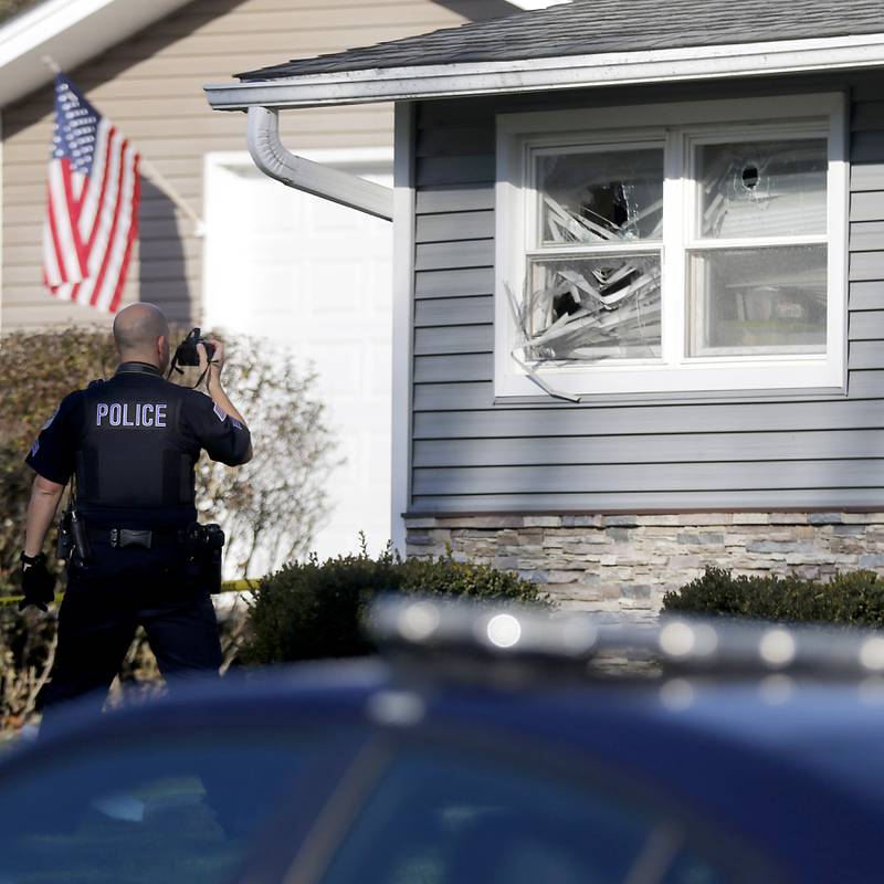 A Johnsburg police officer photographs damaged to a home in the 600 block of Fillmore Road on Wednesday, Nov, 15, 2023. Johnsburg Police officers were dispatched to the home at approximately 11:08 p.m. Tuesday, for a man shooting a gun inside the house. Police believed it the situation to be a mental health incident and the standoff began.