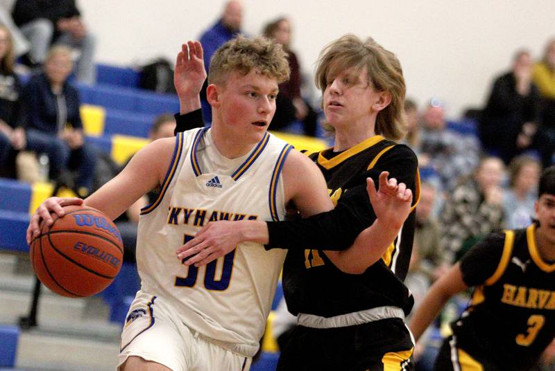 Harvard’s Coen Dacy, right, guards Johnsburg’s Jayce Schmitt, left, in varsity boys basketball at Johnsburg Saturday.