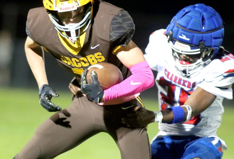 Jacobs’ Carson Goehring, left, gets past Dundee-Crown’s Ereyon Bailey in varsity football  at Jacobs High School in Algonquin on Friday, Oct. 10, 2025.
