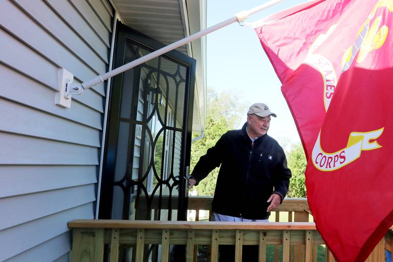 Mike Kopala, a Vietnam-era Marine Corps veteran from Lake in the Hills, exits his front door during a Habitat for Humanity of McHenry County home dedication ceremony on Saturday, May 29, 2021 in McHenry.  The project rehabilitated the existing residence to include a new garage, updated plumbing, heating, energy-efficient windows, and more.