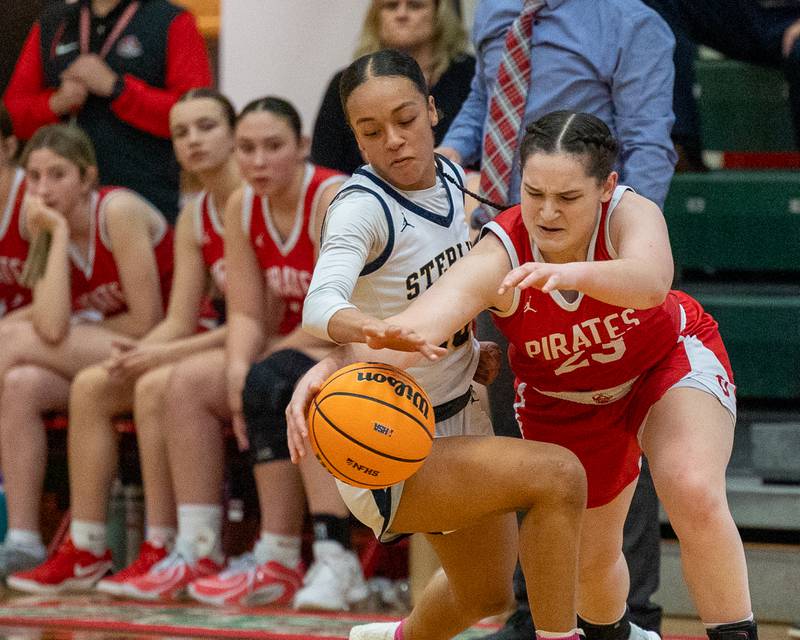 Mary Stisser (23) of Ottawa and Nia Harris (10) of Sterling reach for loose ball during Regional Championship game on Thursday, Feb. 19, 2026 in Sellett Gymnasium at L-P High School.