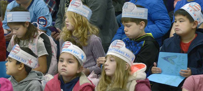 Students from Serena Grade School wear specially made hats as they sit in the audience during a Veterans Recognition Ceremony Tuesday  at Serena High School.