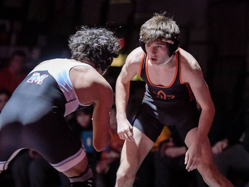 St. Charles East’s Liam Aye and Marian Central’s Anthony Alanis wrestle at 120 pounds during a match in St. Charles on Wednesday, December 20, 2023.