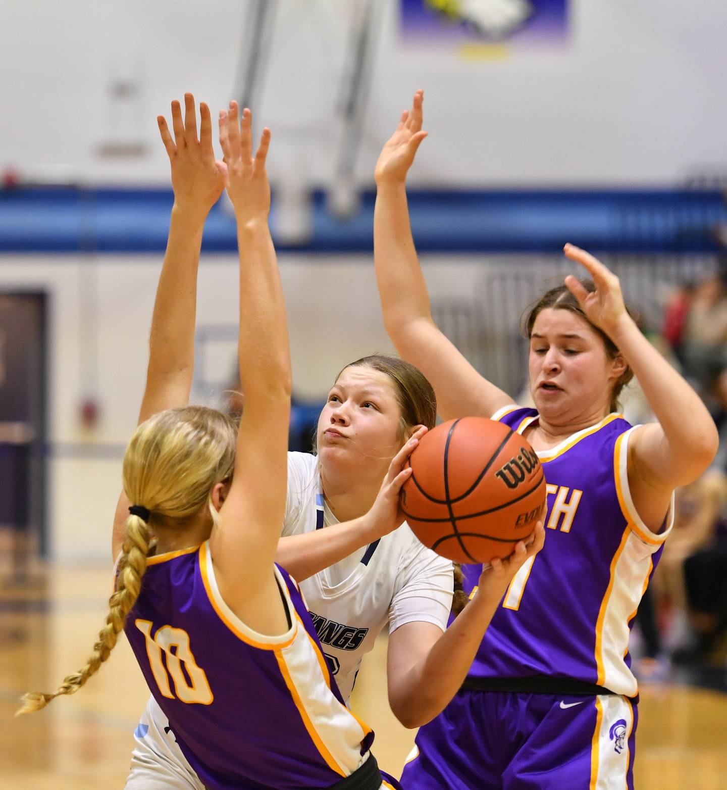 Downers Grove South's Megan Ganschow (middle) looks to shoot while double teamed by Downers Grove North's Hope Sebek (10) and Annie Stephens during a crosstown game on Dec. 17, 2022 at Downers Grove South High School in Downers Grove .