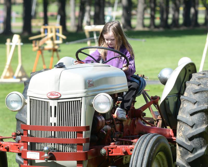 Pre-kindergartener Memphis Mongan checks out the vintage Ford tractor at the Oregon High School's FFA agriculture event on Friday, May 9, 2025. FFA kids brought their tractors to the Oregon Elementary School for grade school students to explore. A petting zoo with a variety of animals cared for by FFA students was also part of the event.