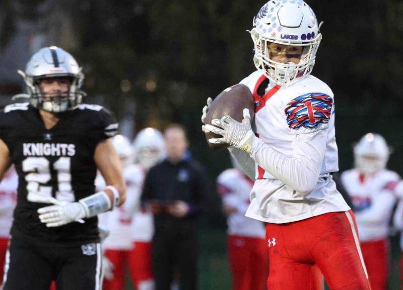 Lakes' Chase Davis makes a catch in front of Kaneland's Jackson Little Saturday, Nov. 1, 2025, during their first round playoff game at Kaneland High School in Maple Park.