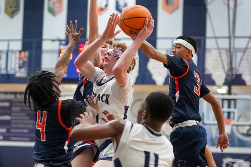 Oswego East's Andrew Pohlman (21) shoots the ball in the post against Oswego’s Tyrell Mays (4), Brayden Borrowman (30) and Ethan Vahl (3) during a basketball game at Oswego East High School on Saturday, January 14, 2017.