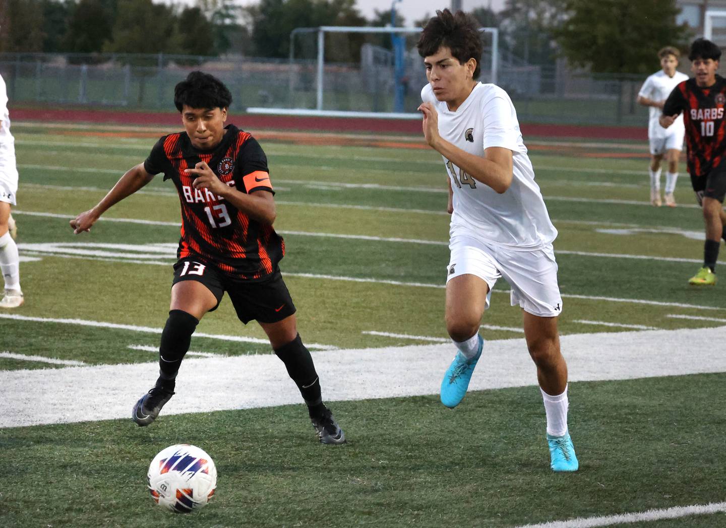 DeKalb's Henry Garcia-Alvarez (left) and Sycamore's Javier Lopez race to the ball during their game Thursday, Oct. 10, 2024, at DeKalb High School.