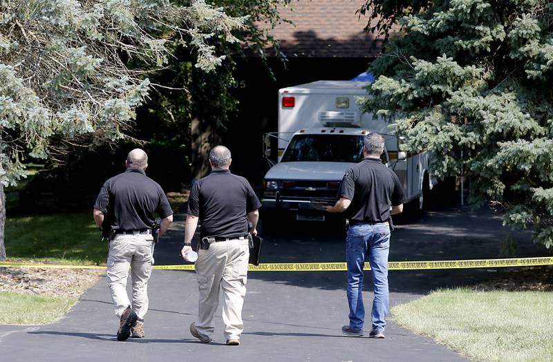 McHenry County Sheriff's office investigators walk toward a home in 5800 block of Wild Plum Road in unincorporated Crystal Lake on Thursday, Aug. 10, 2023, as they continued to investigate the scene where four family members, including three females and a male “aggressor,” were killed Wednesday.