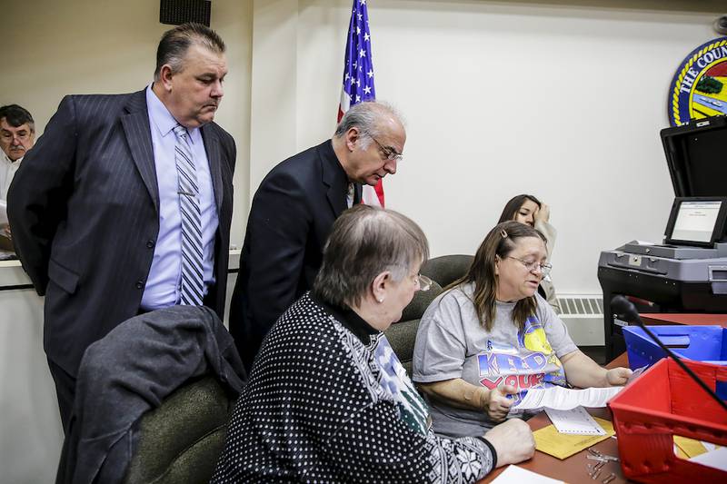 Will County Sheriff candidate Mike Kelley (left) watches as provisional and absentee ballots are counted Tuesday at the Will County Office Building. Kelley had a 471-vote edge in the final count.