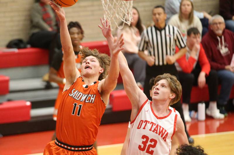 Sandwich's Nick Michalek runs in for a layup as Ottawa's Aric Threadgill defends on Wednesday, Dec. 4, 2024 in Kingman Gym at Ottawa High School.