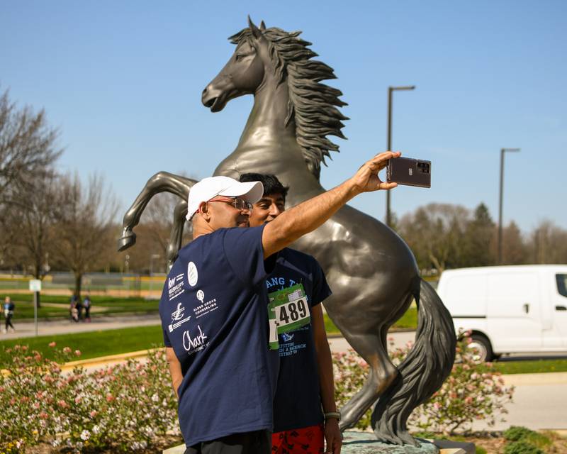 Slooby Jose of woodridge and his son Jude Slooby, 13, of wooddridge take a selfie with the Mustang outside of Downers Grove South High School after they took part in the Mustang Trot on Sunday April 14, 2024.