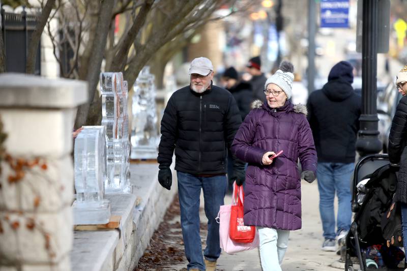 Carl and Susan Wagner of Willow Springs walk past some of the ice sculptures on display during the Downtown Downers Grove Ice Festival on Saturday, Feb. 1, 2025 in Downers Grove.
