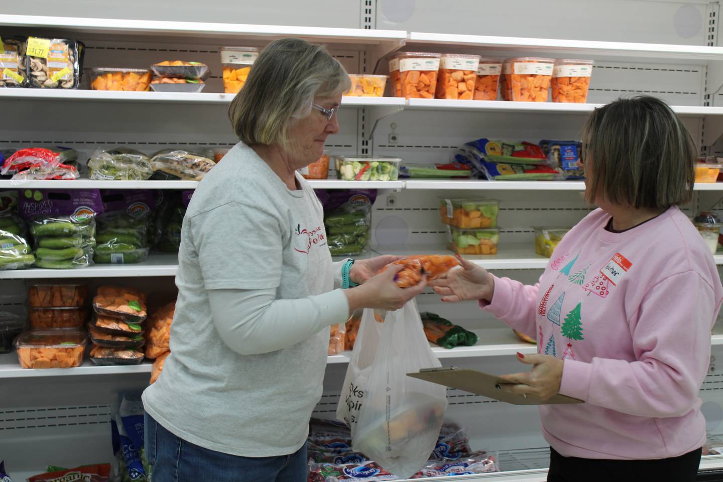 Crystal Lake Food Pantry volunteers Heather Marts and Joanna Bradshaw gather food for a client order.