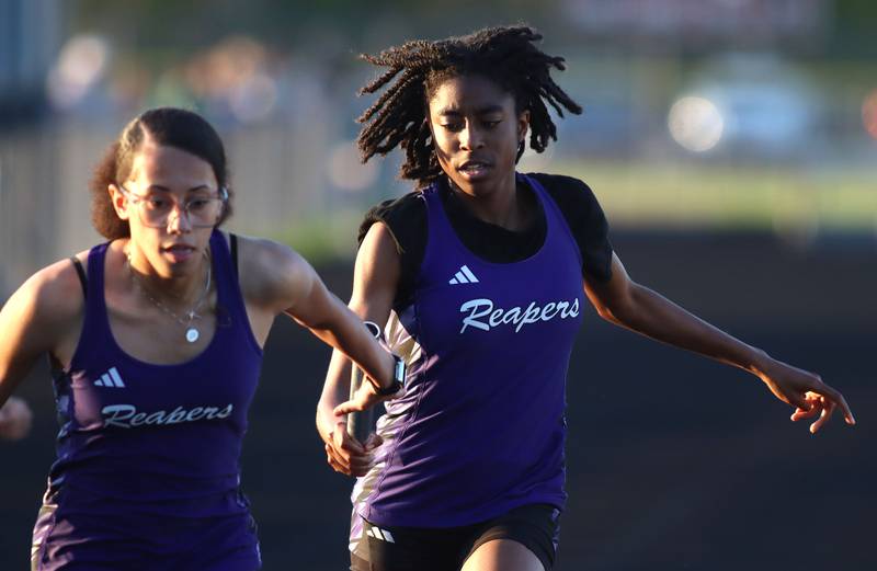 Plano’s Luniah Gilford, right, hands off to Jayda Burau in the 800-meter relay during KRC Conference Track Meet action at Marengo High School in Marengo on Tuesday, May 6, 2025.